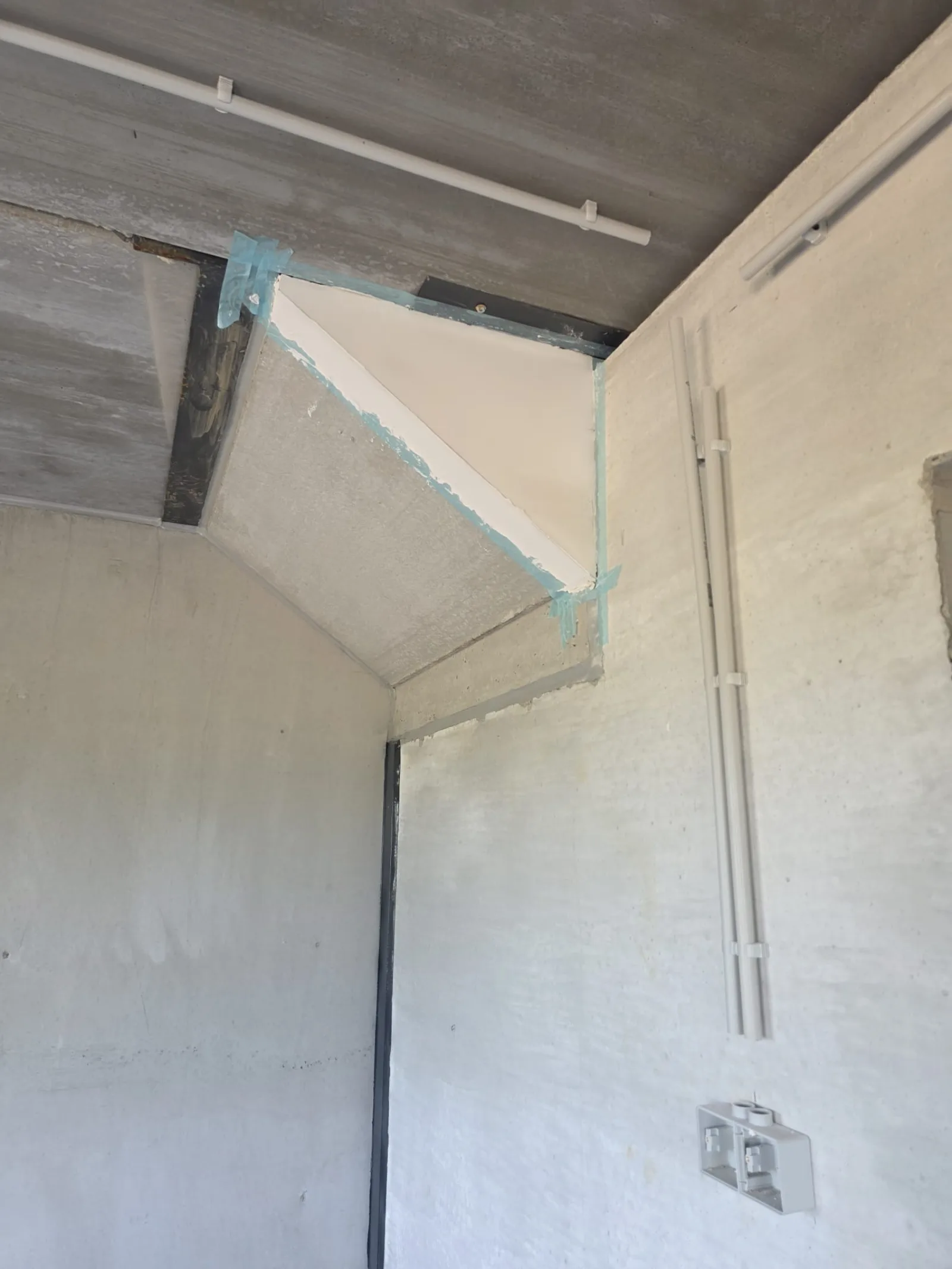 Détail d'un retour de plafond plâtré avec ruban d'étanchéité sur le pourtour